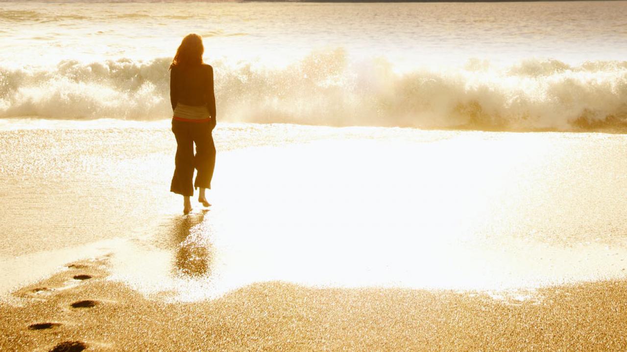 日落时一个女人站在海滩上