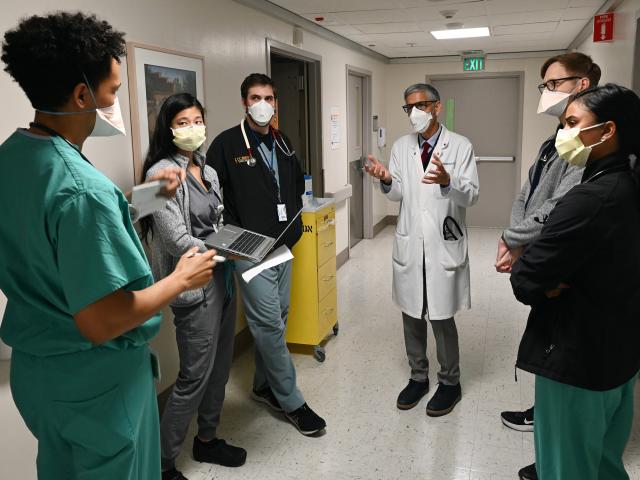穿着白大衣的医生在医院里与医科学生交谈