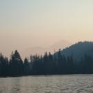 青山绿树映衬下的城堡湖上空的烟雾 
