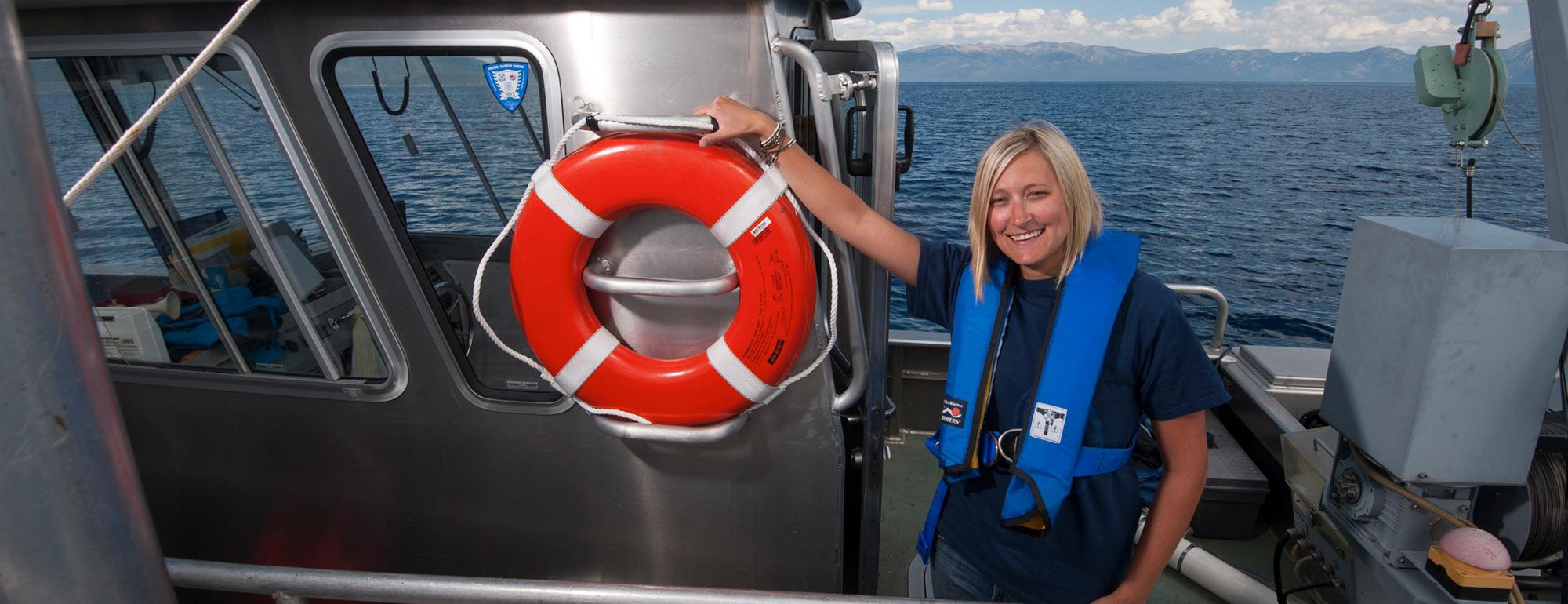 一名女性研究员在太浩湖上的一艘研究船上拍照