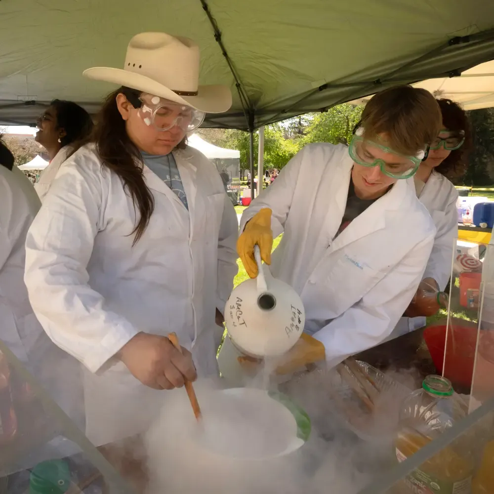 Students work to make liquid nitrogen sorbet and have to work through the fog of the nitrogen as it boils away during Picnic Day