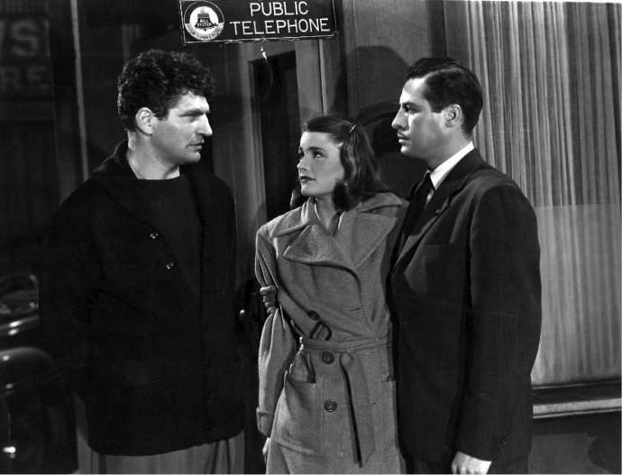 Old noir-style movie set in black and white with two men and a woman talking