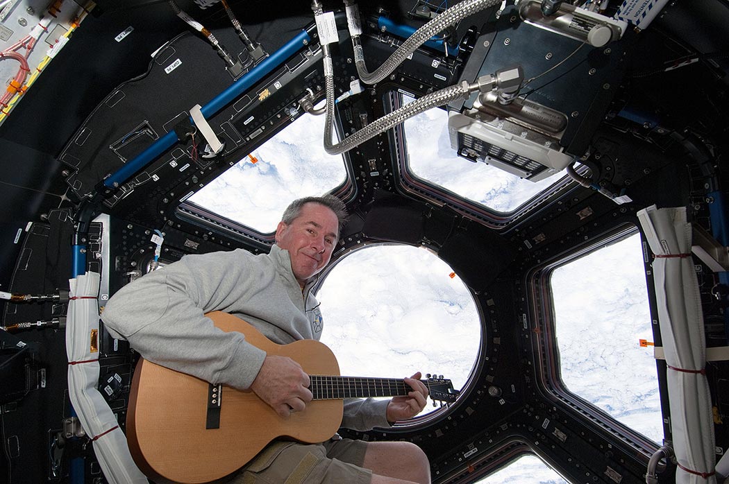 Astronaut Steve Robinson with guitar in the International Space Station