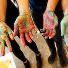 art students showing hands covered in paint
