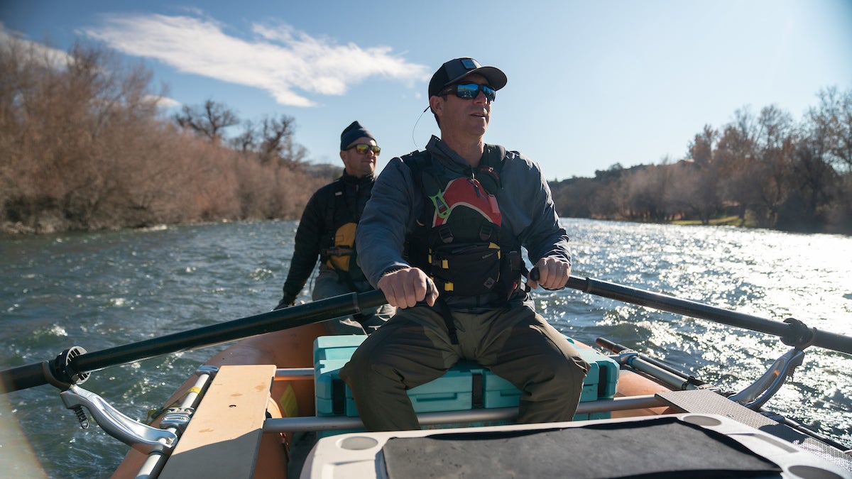 Damon Goodman in cap paddles at front of raft as Robert Lusardi sit in back as raft down Klamath River 