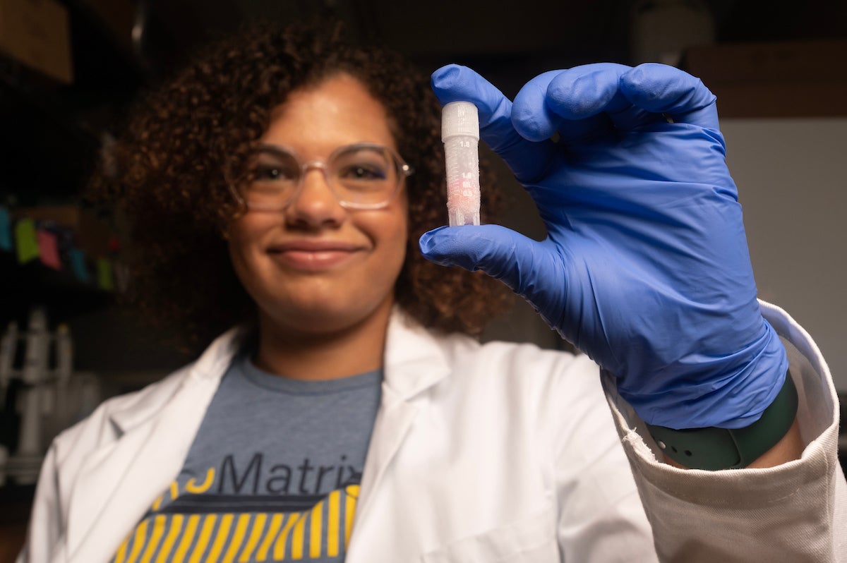 Madison Stewart, a UC Davis graduate research student, holds a pinky-sized white vial of bovine adult stem cells in her hand. The cells can be used as the starting material for cultivated meat. (Gregory Urquiaga / UC Davis)