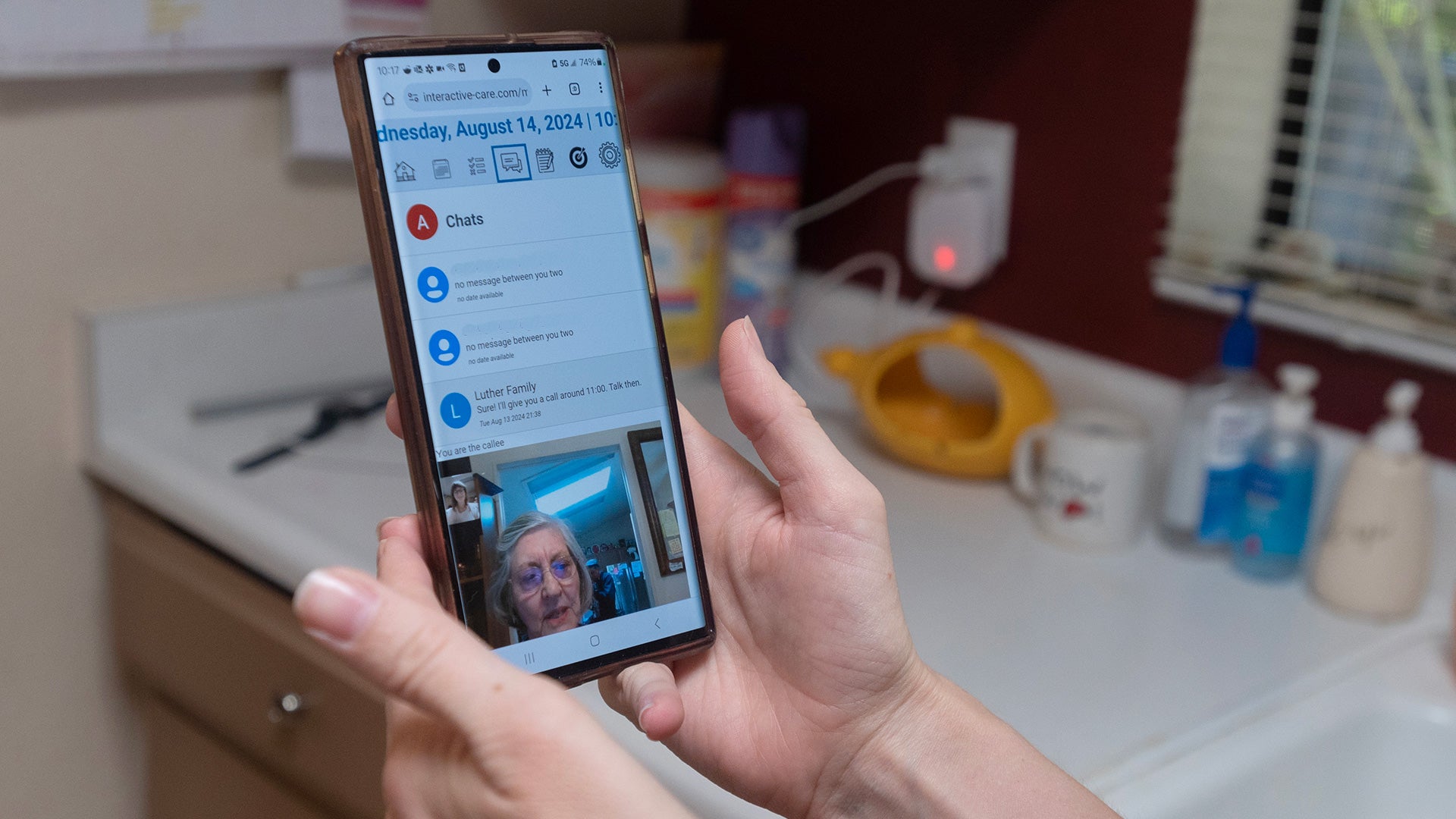 Hands holding a smartphone during a video call