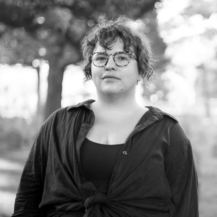 Black and white headshot image of a woman in glasses