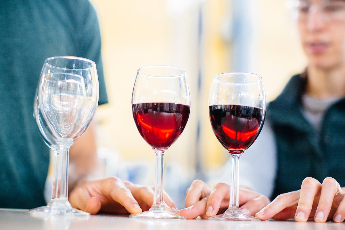 Two glasses of red wine on a table. UC Davis researchers think the flavanol quercetin, when combined with alcohol, may be the cause of 