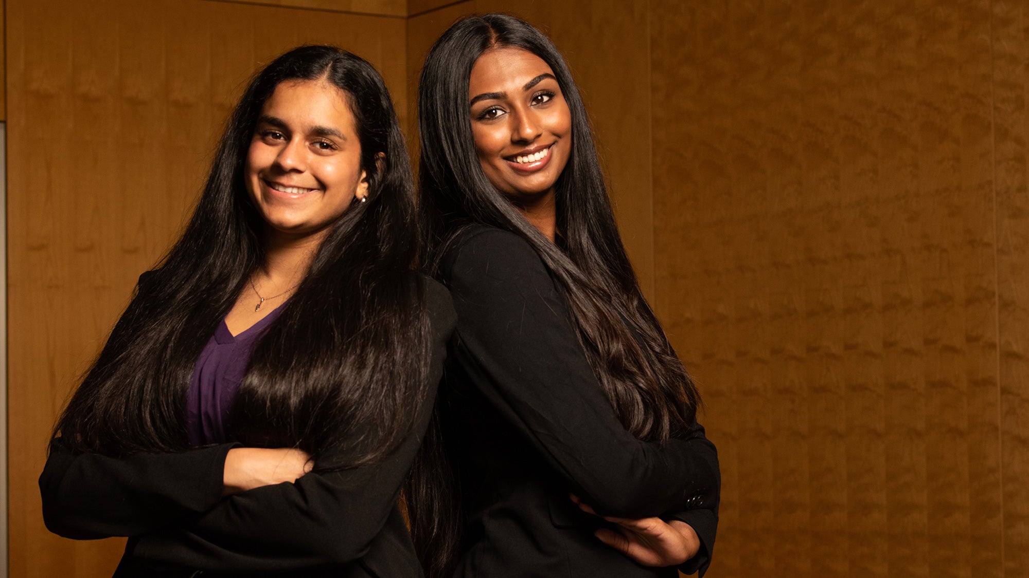 Two students stand back to back