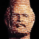 a brick chimney constructed in the likeness of Robert Arneson
