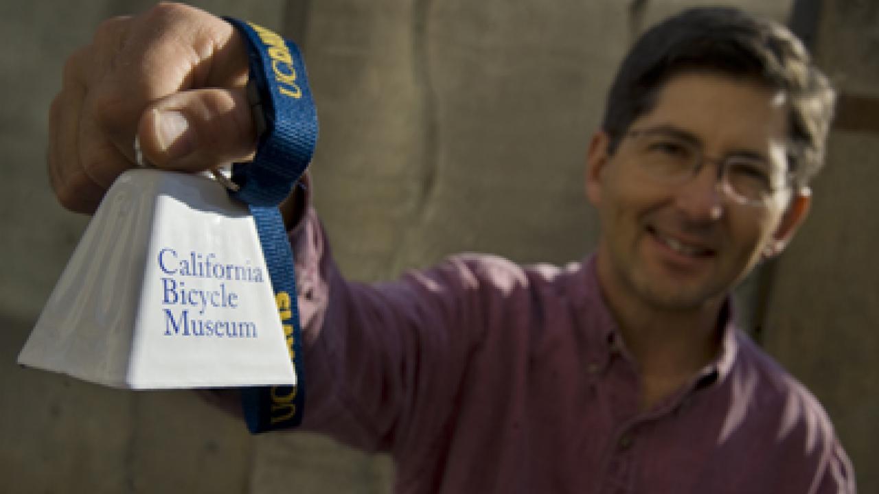 Cell biology researcher John Hess displays the California Bicycle Museum cowbell, made for the Amgen Tour of California.
