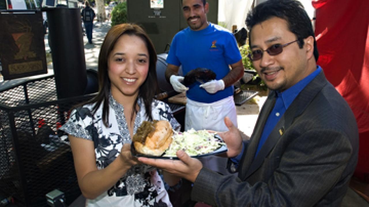 Staff Assembly&rsquo;s Alyssa Varela and Peter Blando display a meal much like those to be served at the 2008 TGFS Picnic on May 7: A Buckhorn Steak & Roadhouse tri-tip sandwich and Granny Smith apple coleslaw. The Buckhorn&rsquo;s Silverio Arteaga did 