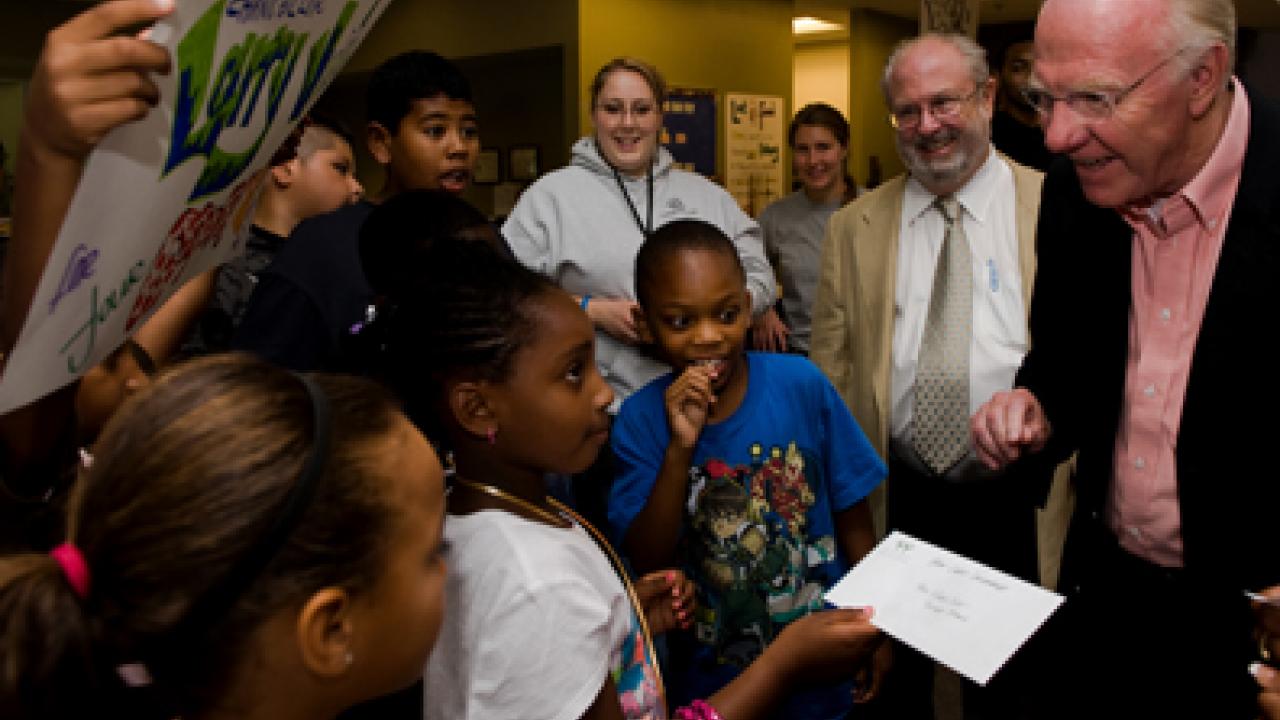 Eight-year-old Anaiya Wilson accepts Chancellor Larry Vanderhoef's $5,000 donation to the Boys & Girls Clubs.