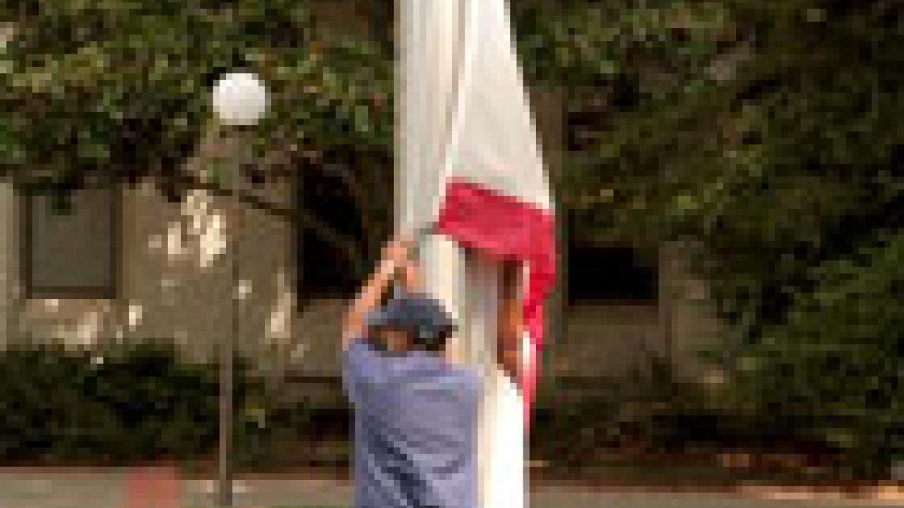 Joe Juarez of  Operations & Maintenance prepares to raise the California flag to half-staff Tuesday in memory of those killed in the Virginia Tech massacre. UC Davis joined other institutions nationwide in this act of remembrance, and will hold 