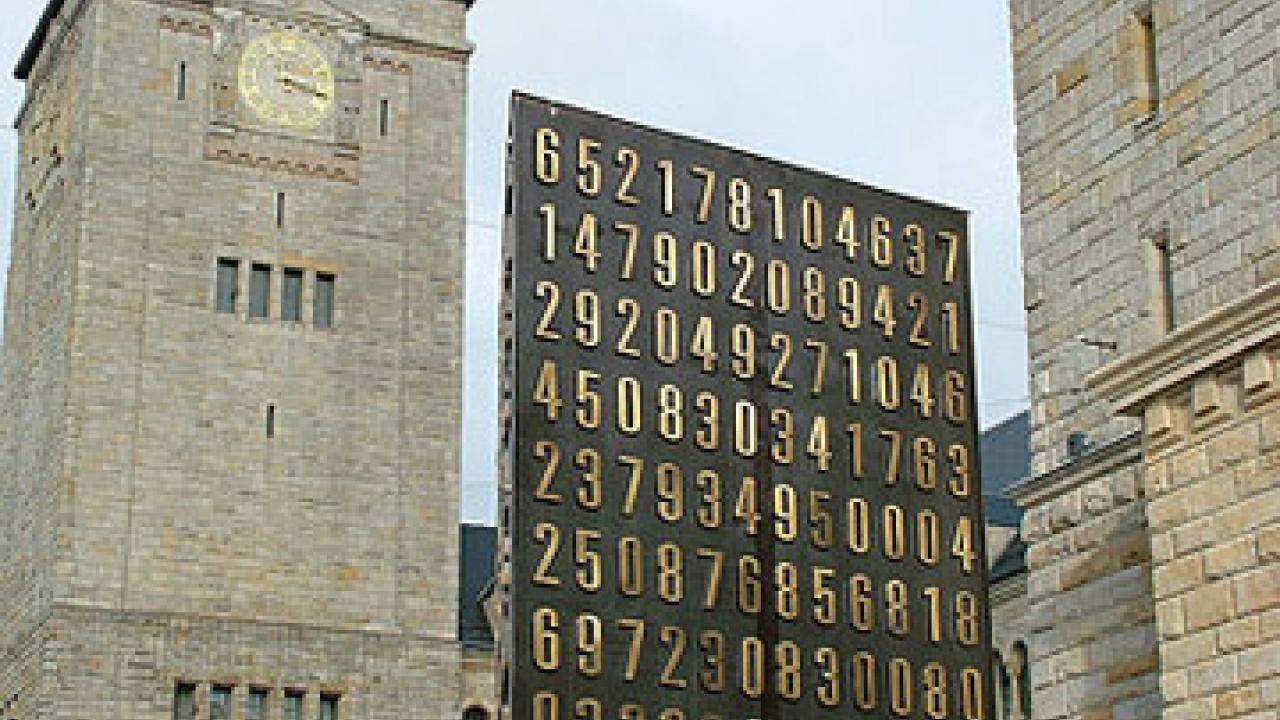 Photo: buildings in Poznan, Poland,  with monument covered in big brass numbers