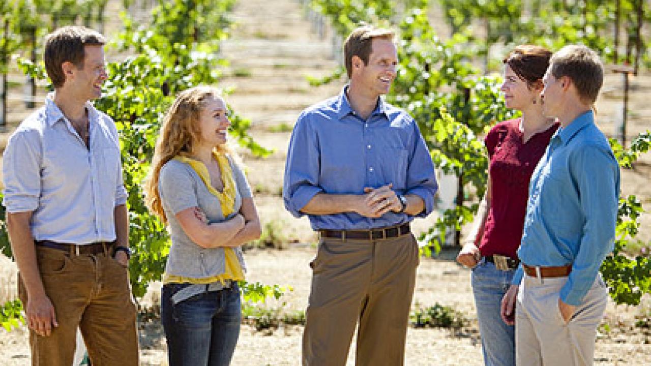 Photo: five people standing in a vineyard