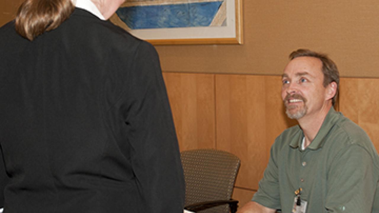 Photo: UC Davis physical therapist Dan Quasius talks with an unidentified job-seeker at the Veterans and Career Diversity Fair, June 3, 2013.