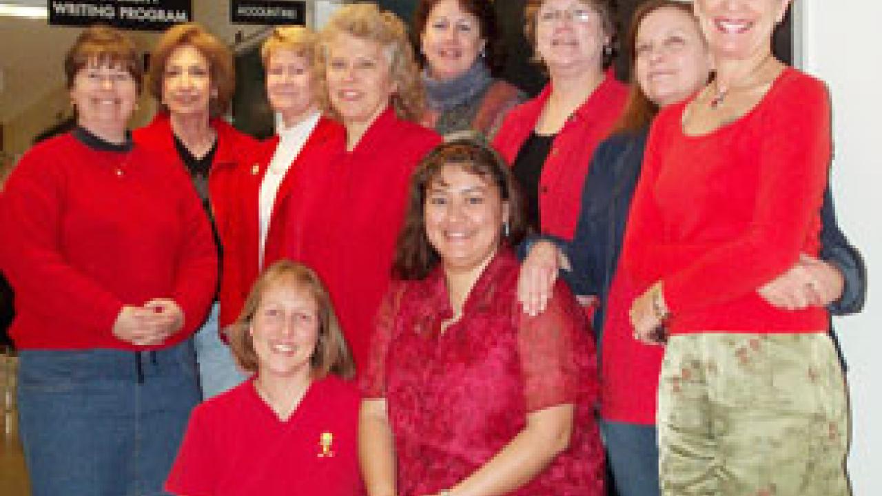 Red-dressers, from left above are: Lynda Jones, Vita Simonsen, Cindy Dufern, Janie Guhin, Mary White, Terry Antonelli, Pam Self, Merlyn Potters; and seated, Melissa Lovejoy and Maria Saldana-Seibert.