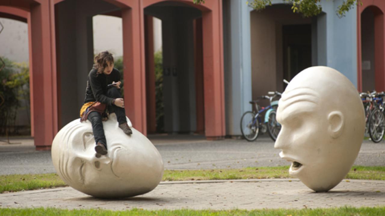 Photo: Unidentified person sits on one of the Eggheads in the "Yin & Yang" installation.