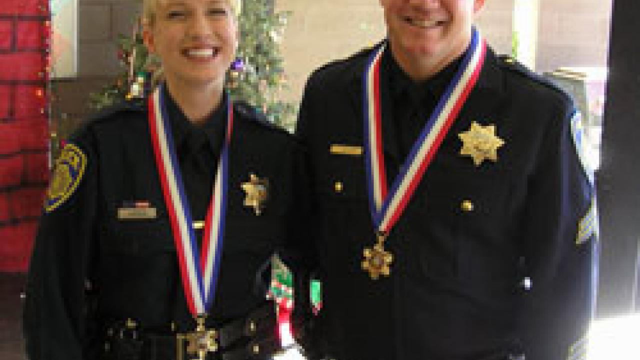 Medal of Valor recipients Officer Franci Abraham and Sgt. Paul Henoch wear the new awards around their necks during a ceremony held Dec. 21 in their honor.
