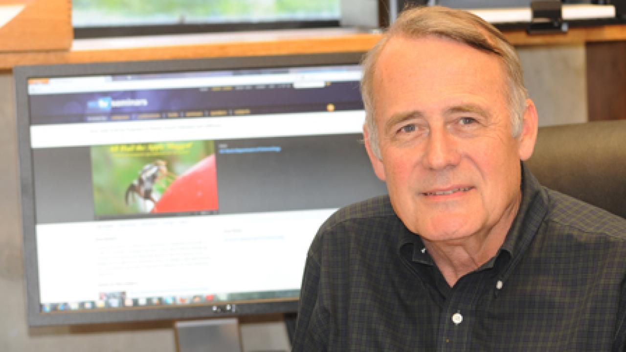 Photo: Professor James Carey in front of a computer monitor