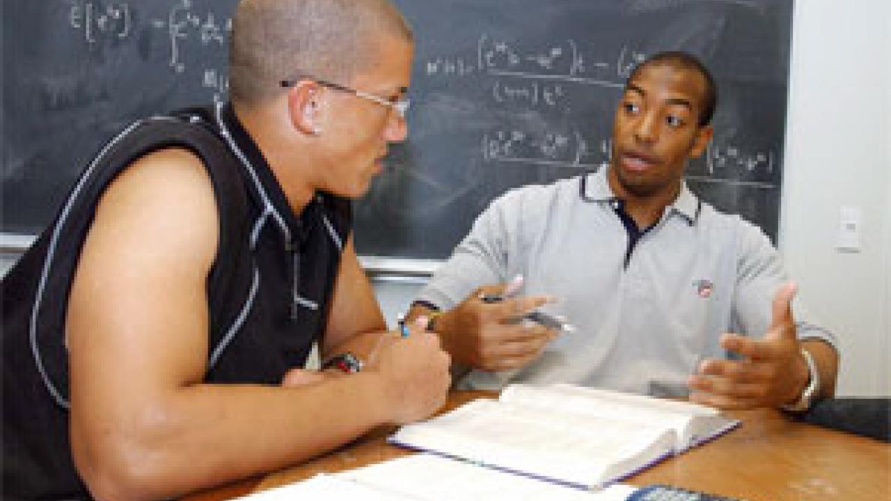 University Medalist Chris Jones, right, tutors freshman football player Brandon Rice in chemistry. His commitments to mentoring, his pre-med studies and hospital work stand among many attributes that distinguish Jones, say coaches and faculty.