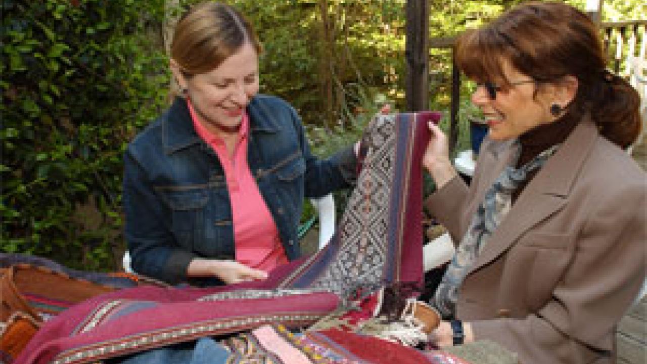 Susan Kaiser, left, and Leslie Rabine  examine textiles from Cusco. The two are major players in developing top-notch textile and fashion programs at UC Davis.