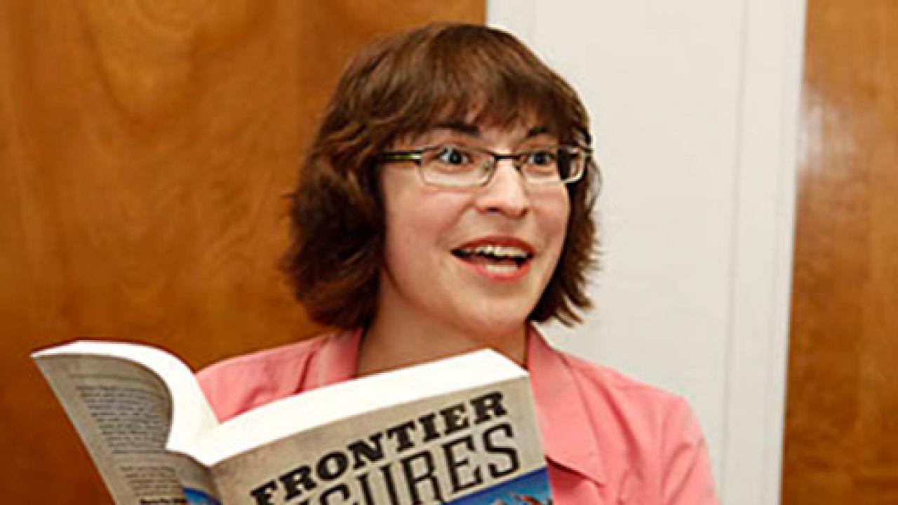 Photo: Musicologist Beth E. Levy, associate professor, holding her book, "Frontier Figures"
