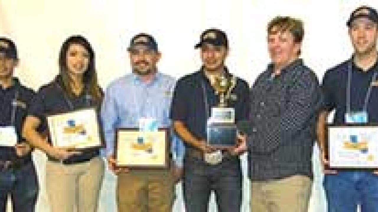 Photo: Students and Meat Lab manager lined up, with certificates and trophy.