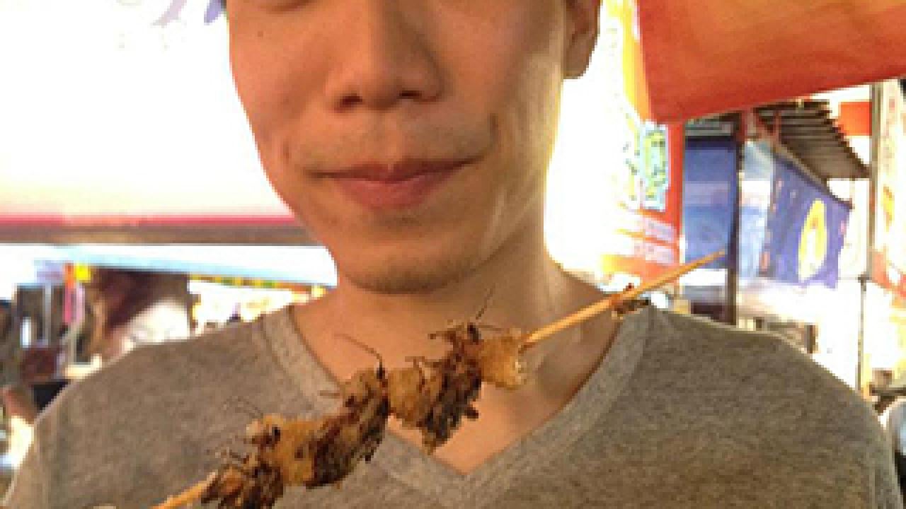 Raymond Lo with fried crickets on a skewer