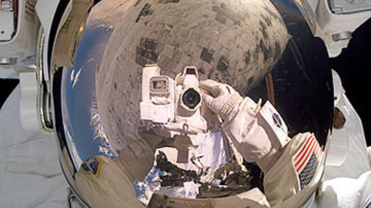 photo: astronaut with camera outside shuttle in space