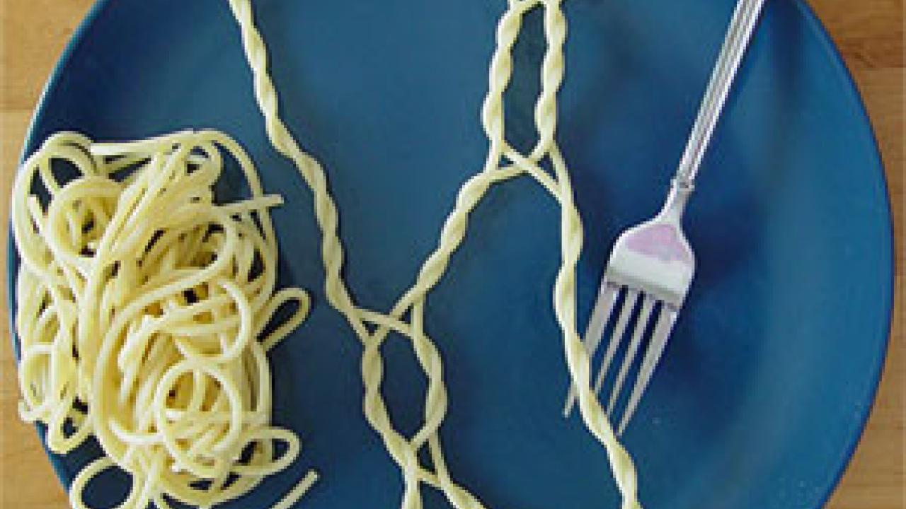 Photo: fork with twisted spaghetti on blue plate