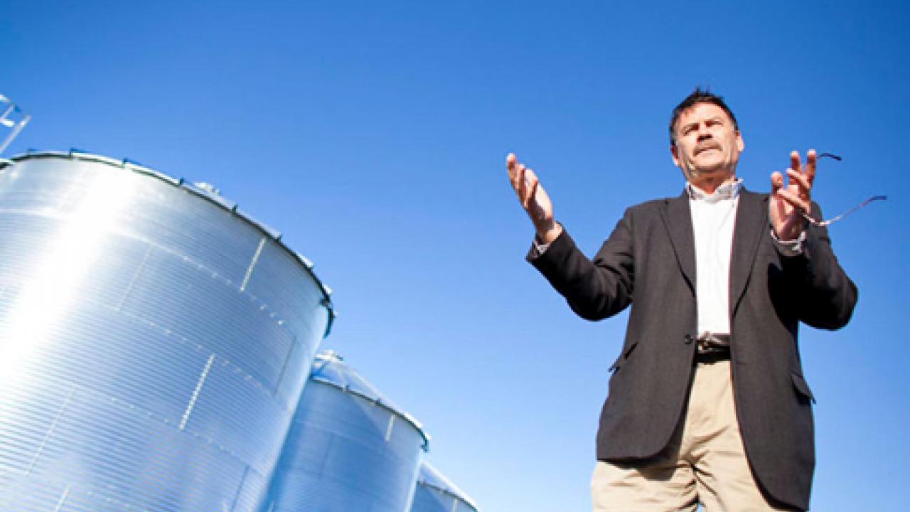 Photo: Professor Roger Boulton stands in front of rainwater collection tanks at the campus's winery-brewery complex.