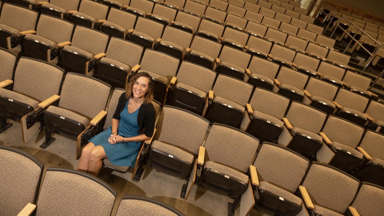 Laci Gerhart sits in one of many lecture hall seats shown