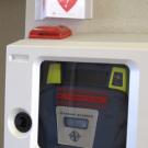 Photo: Automated external defibrillator and "AED" sign on a wall in the lobby of Mrak Hall