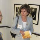 Chancellor Linda Katehi chats with Mark Katrikh of the Museum of Tolerance against a backdrop of photos of Holocaust survivors.