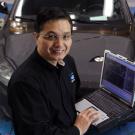 Photo: Ming Kuang with laptop computer and car