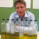 Dan Flynn displays bottles containing samples of oil from various trees harvested on different days; the samples are used in the blending process.