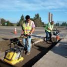UC employees Enrique Ruiz, left, and Vince Lampman repair a rut in a Hutchison Drive approach.