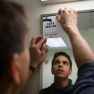 Photo: Student Jordan Ramalingam affixes a "Save Water" cling to a bathroom mirror.