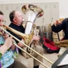 photo of D. Kern Holoman working with musicians Bob Rucker, on the tuba, and Rebecca Brover, on the trombone, who are among those going to France this