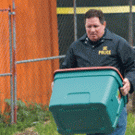 Sgt. Paul Henoch of the UC Davis Police Department carries a container out of the student dorm room where explosive materials were found March 6.