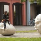 Photo: Unidentified person sits on one of the Eggheads in the "Yin & Yang" installation.