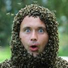 Photo: Jakub Gabka from the shoulders up, with an estimated 15,000 bees making a "helmet" on his head (his face is mostly free of bees).