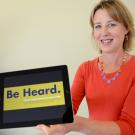 Photo: Kathy Henderson and her new iPad, open to the "Be Heard" slogan of the Campus Community Survey.