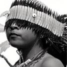 photo: Indian boy in headdress covering his eyes