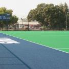 Photo: New field hockey field, showing the artificial turf and blue sideline area, and the scoreboard.