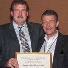 Photo: Chip Israel, outgoing president of the IES, hands framed certificate to Professor Konstantinos &ldquo;Kosta&rdquo; Papamichael.