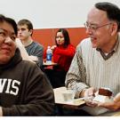 Photo: Female student turns to professor with piece of cake